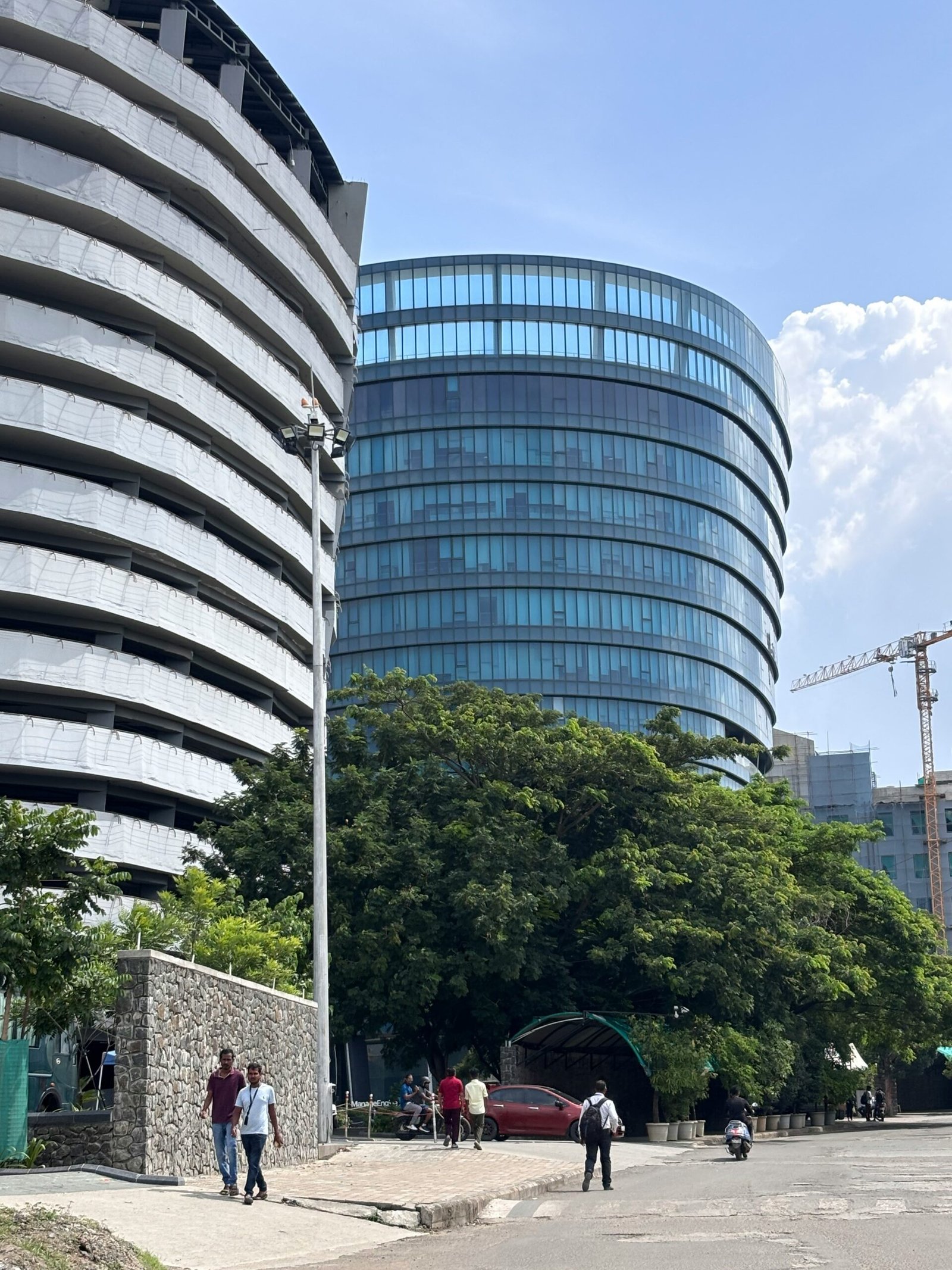 A group of people walking down a street next to tall buildings